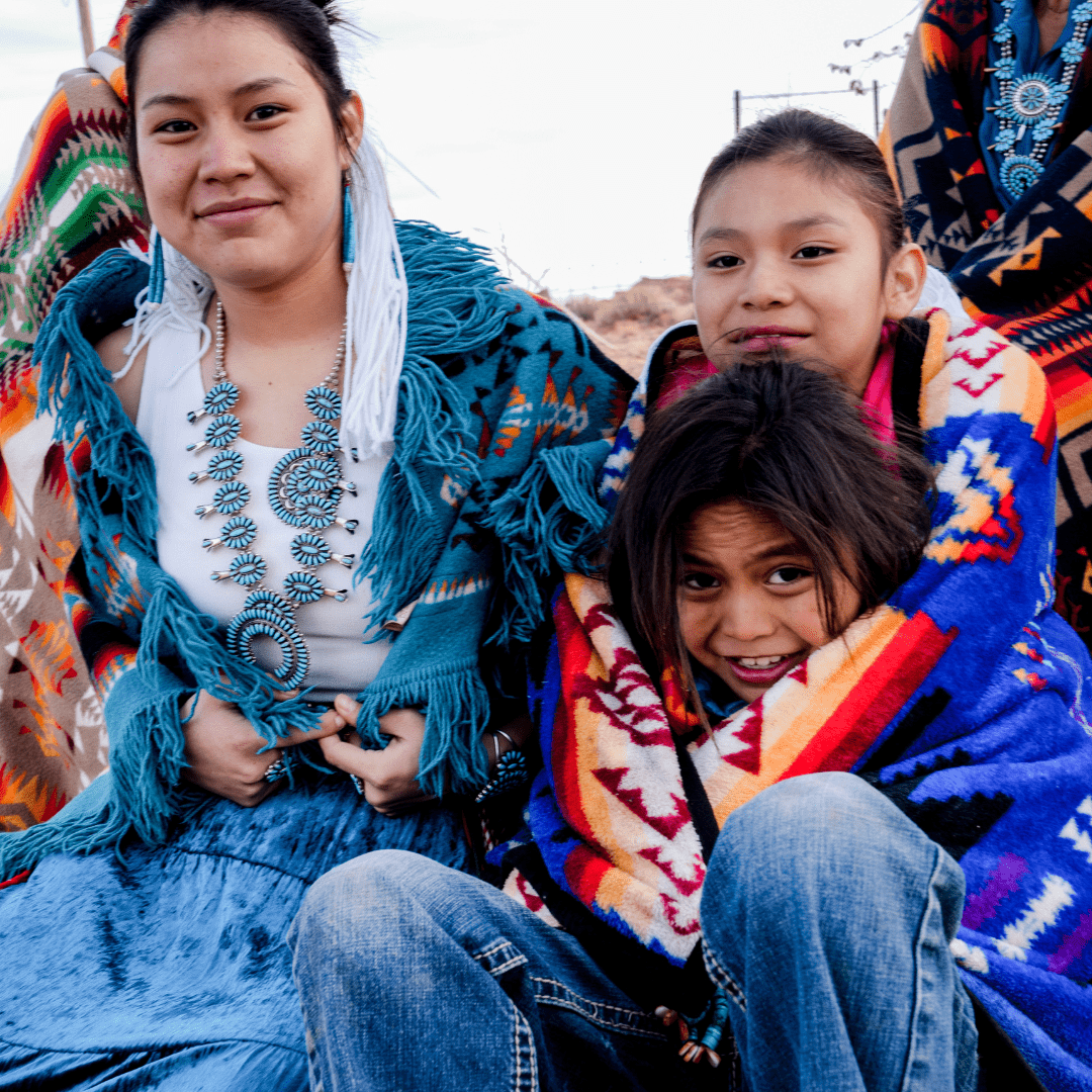 Native American woman and children smiling and looking at the camera