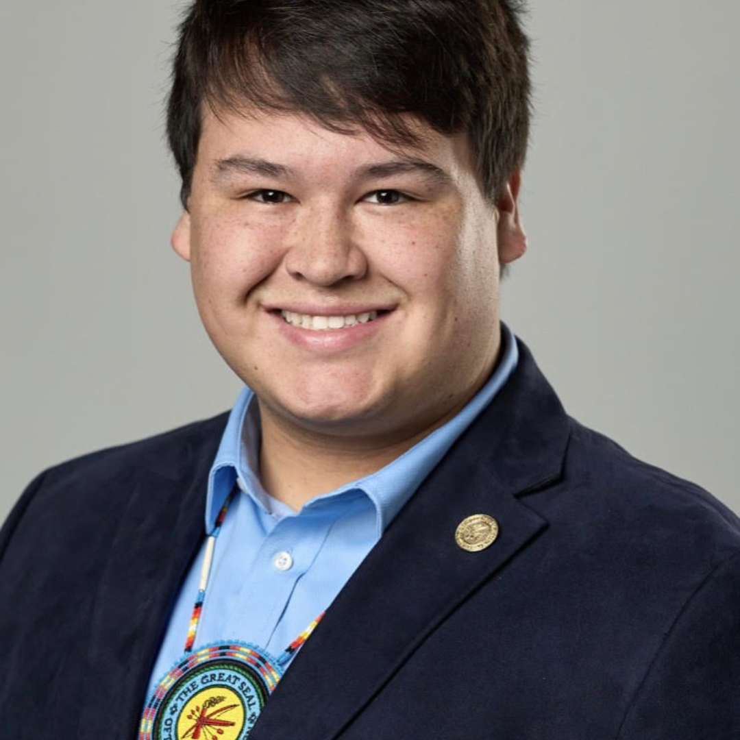 head shot of you man in blue collared shirt and black suit jacket