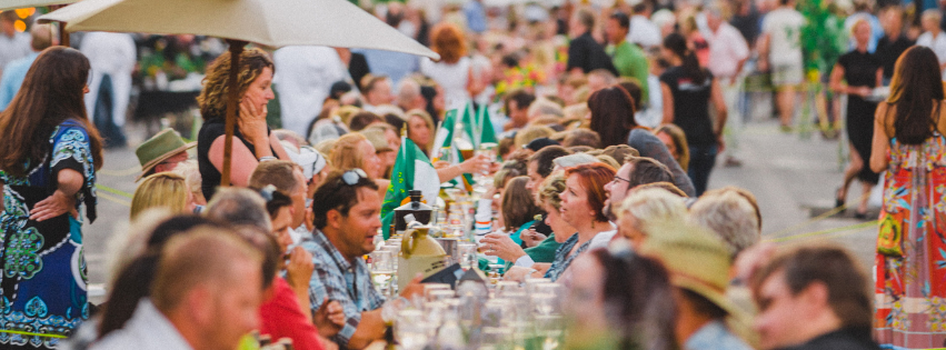 group of people eating at a table outside