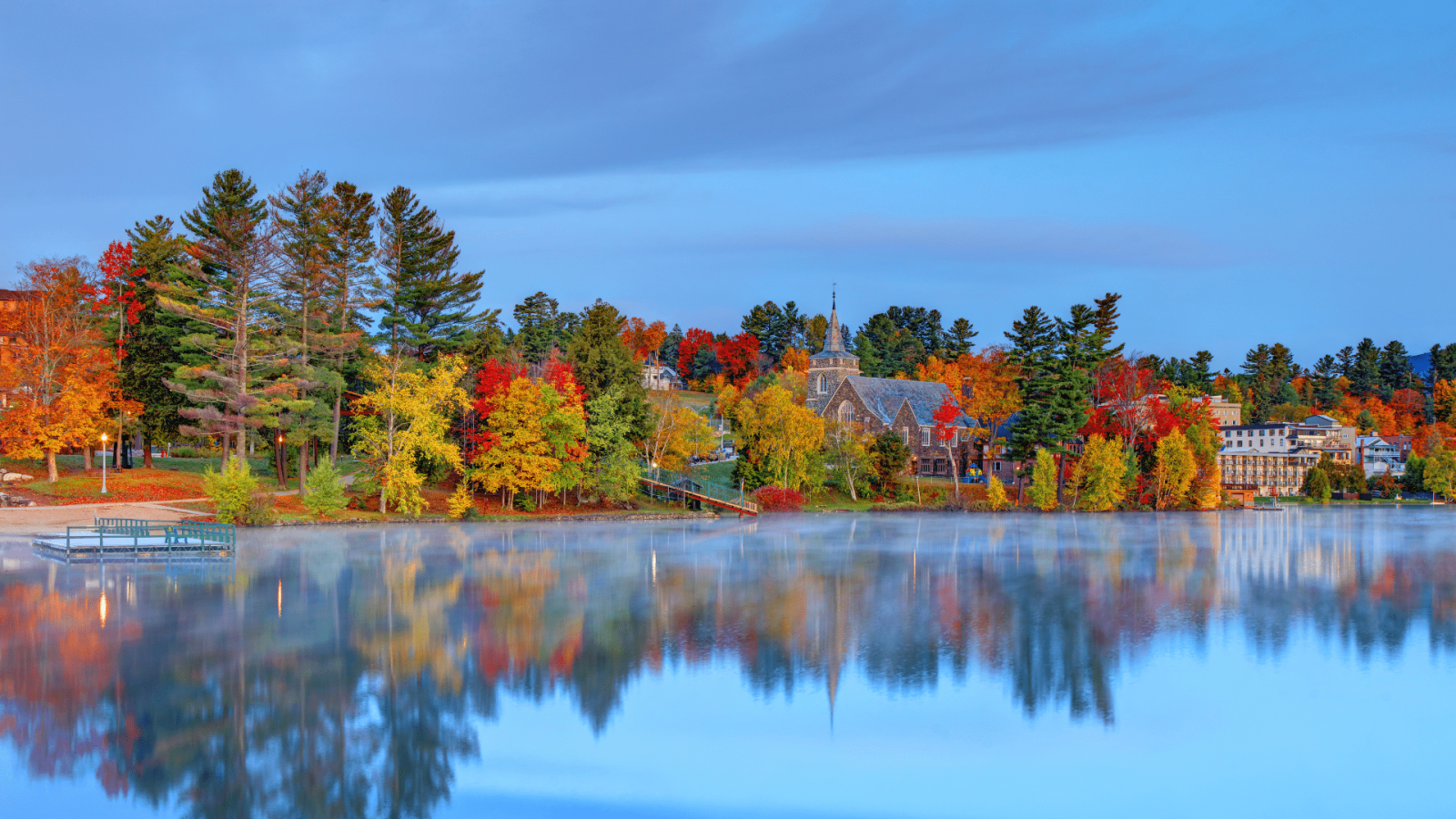 trees in autumn along lake placid